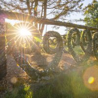 A sunset viewed through the "Prayer Garden" fence.